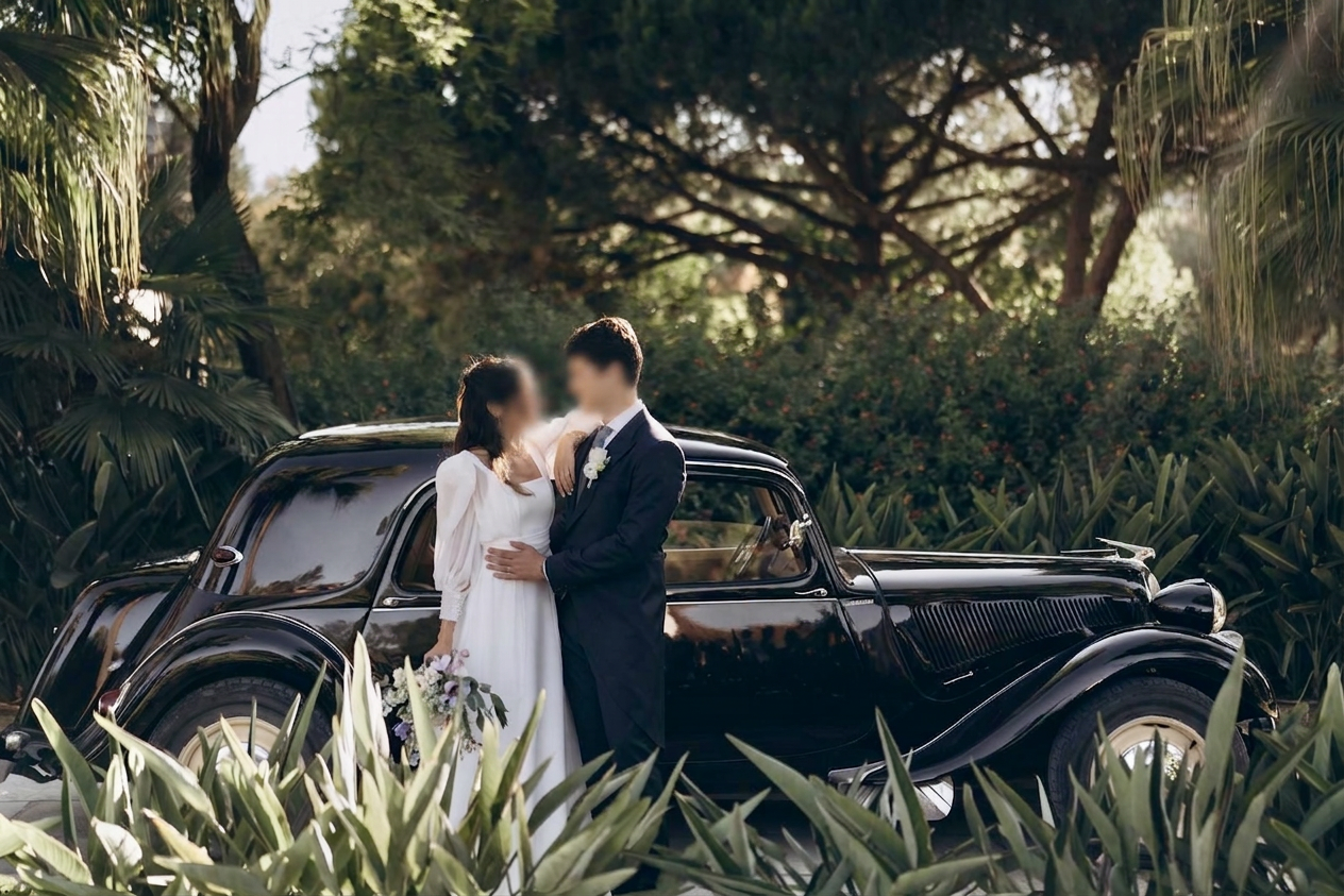 Noivos abraçados junto a Citroën Traction preto num jardim tropical