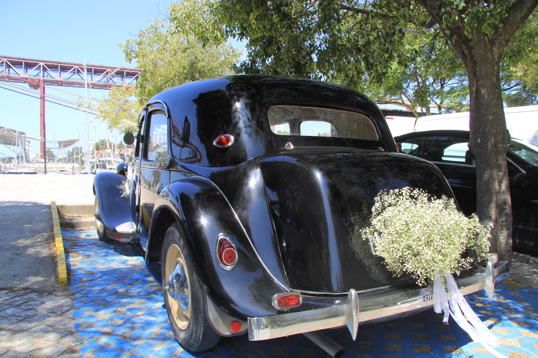 Vista traseira do Citroën Traction preto com decoração floral de noiva junto ao Tejo, A&M Wedding Cars